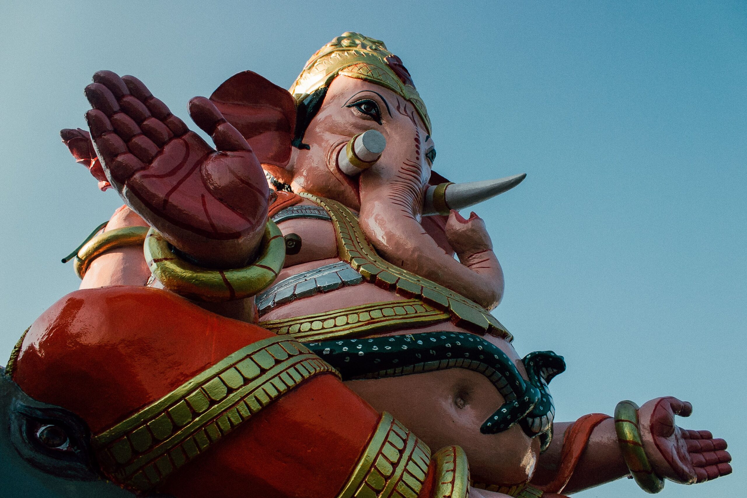 Low angle of aged statue of buddhist elephant with spread hands on cloudless day